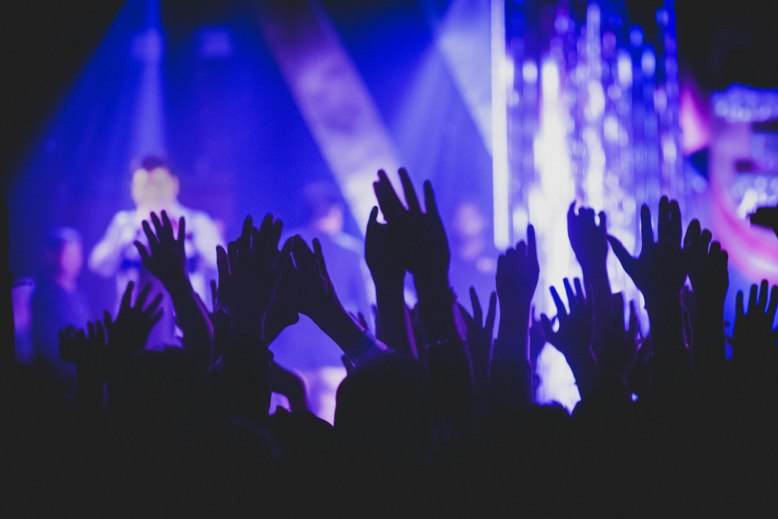 Vibrant music concert scene with crowd and colorful stage lights.